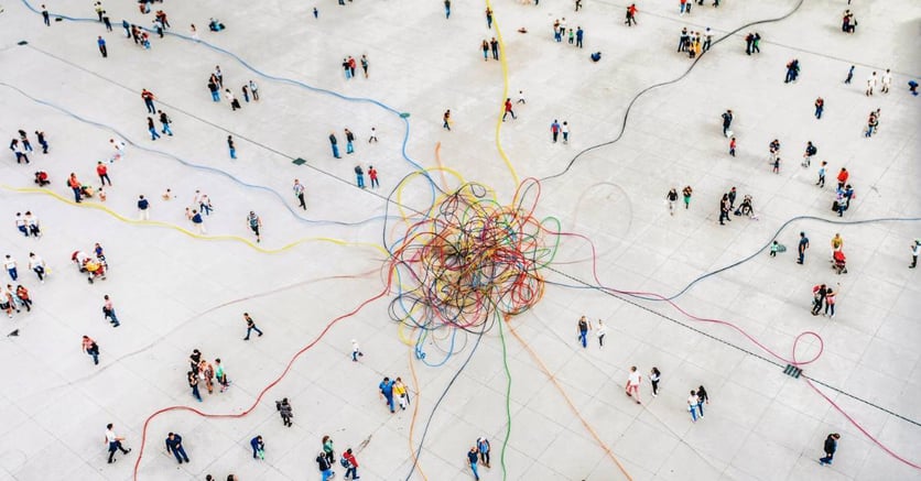 A crowd of people separated by tangled multicolored cables