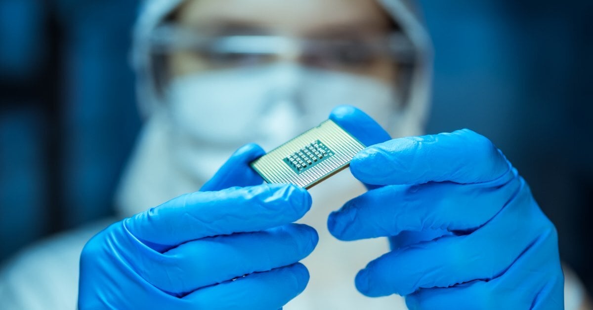 A technology manufacturing worker holds a computer chip