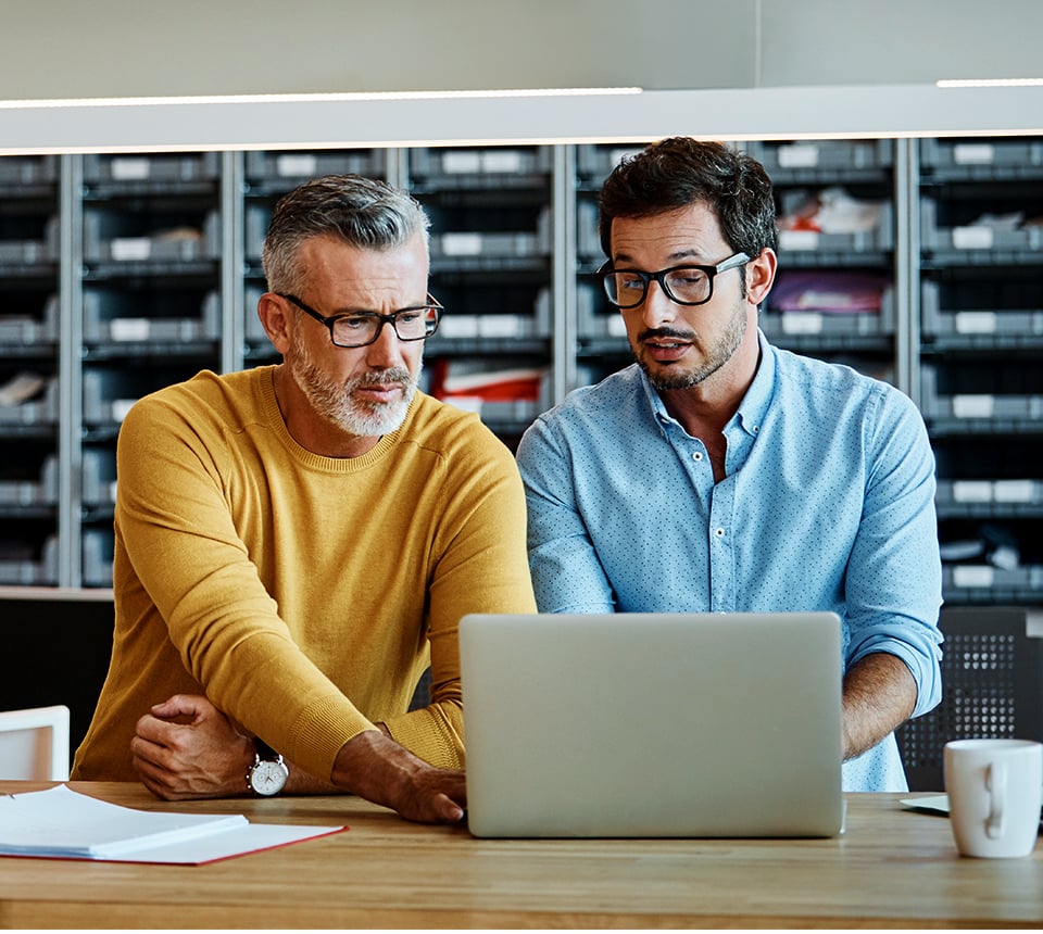 Two individuals sharing a laptop