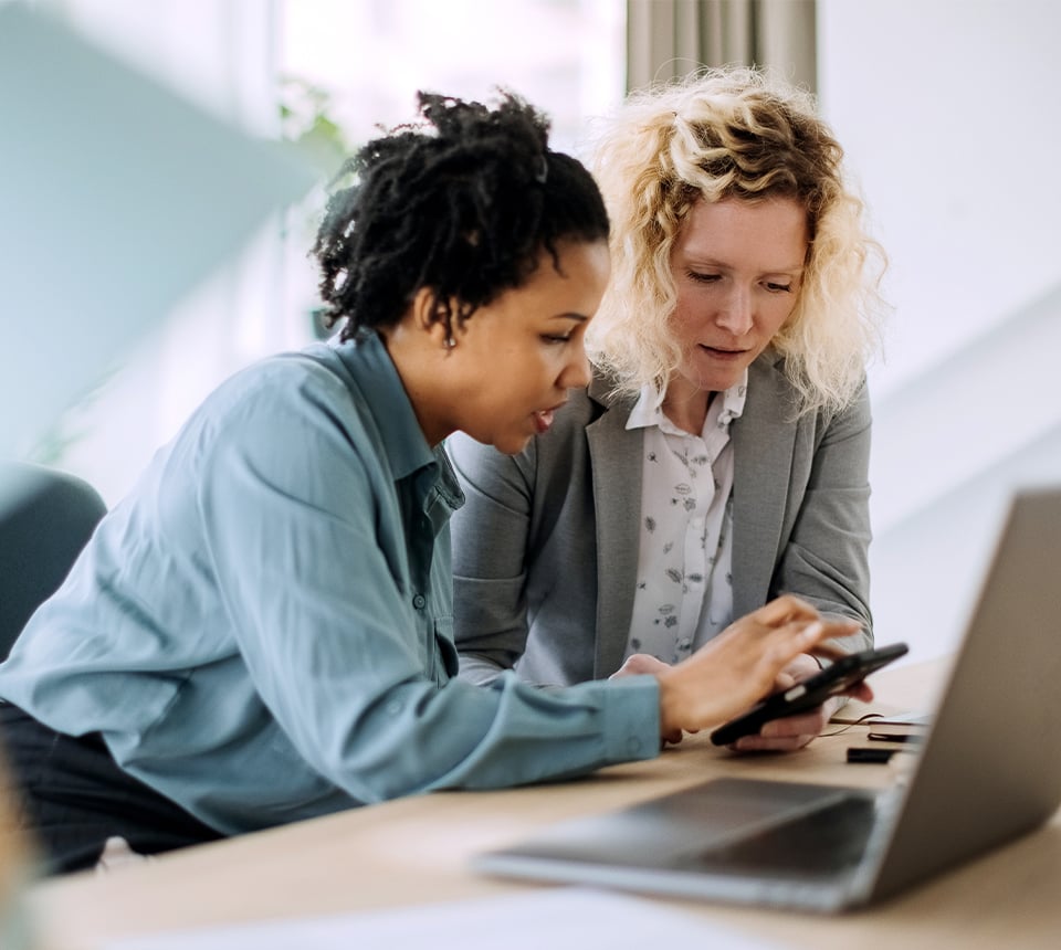 Two individuals sharing a phone