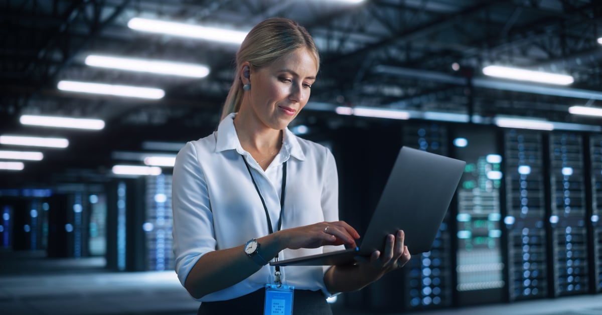 Employee holding laptop.