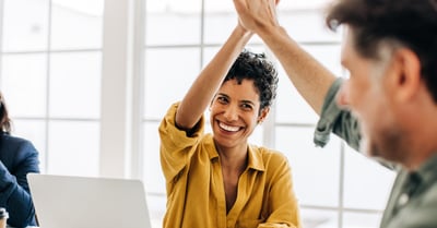 Happy employees high five each other after their workweeks are simplified with print management software for SMBs.