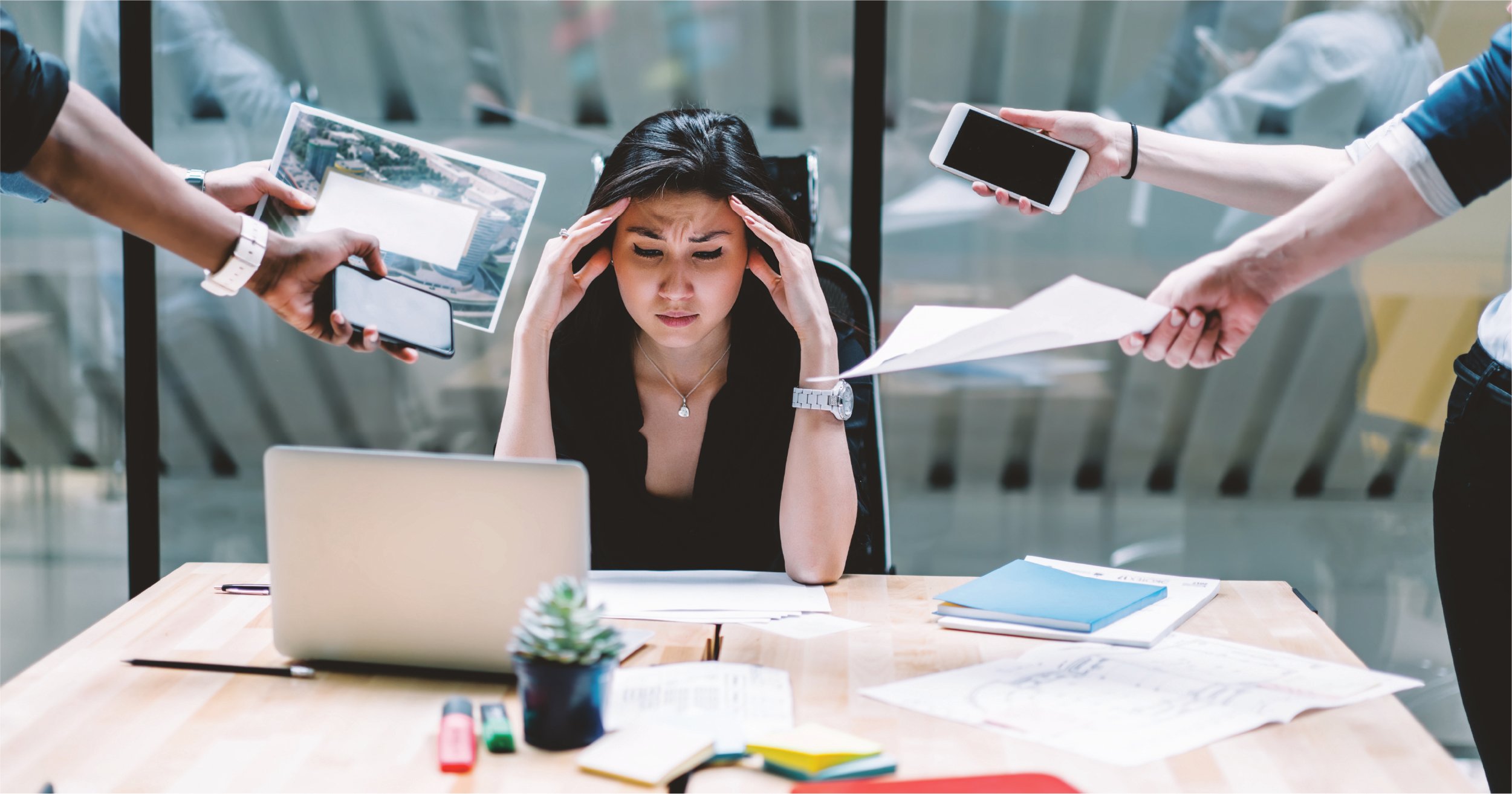 Employee frustrated with people bringing her papers and devices.
