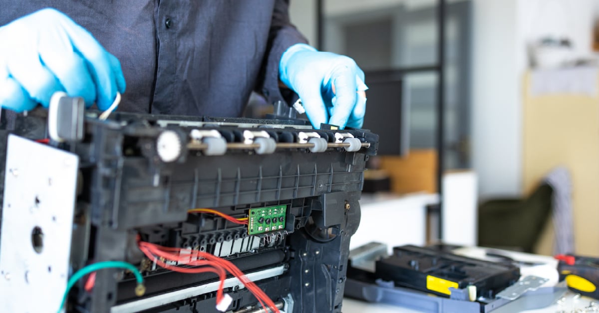 Printer technician working on printer. 