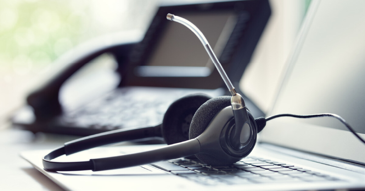 A VoIP headset lies next to a laptop between video conferencing meetings.